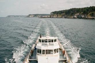 Ferry passagers traversant la mer entre Lorient et l'île de Groix avec sillage blanc sur eau bleue-verte